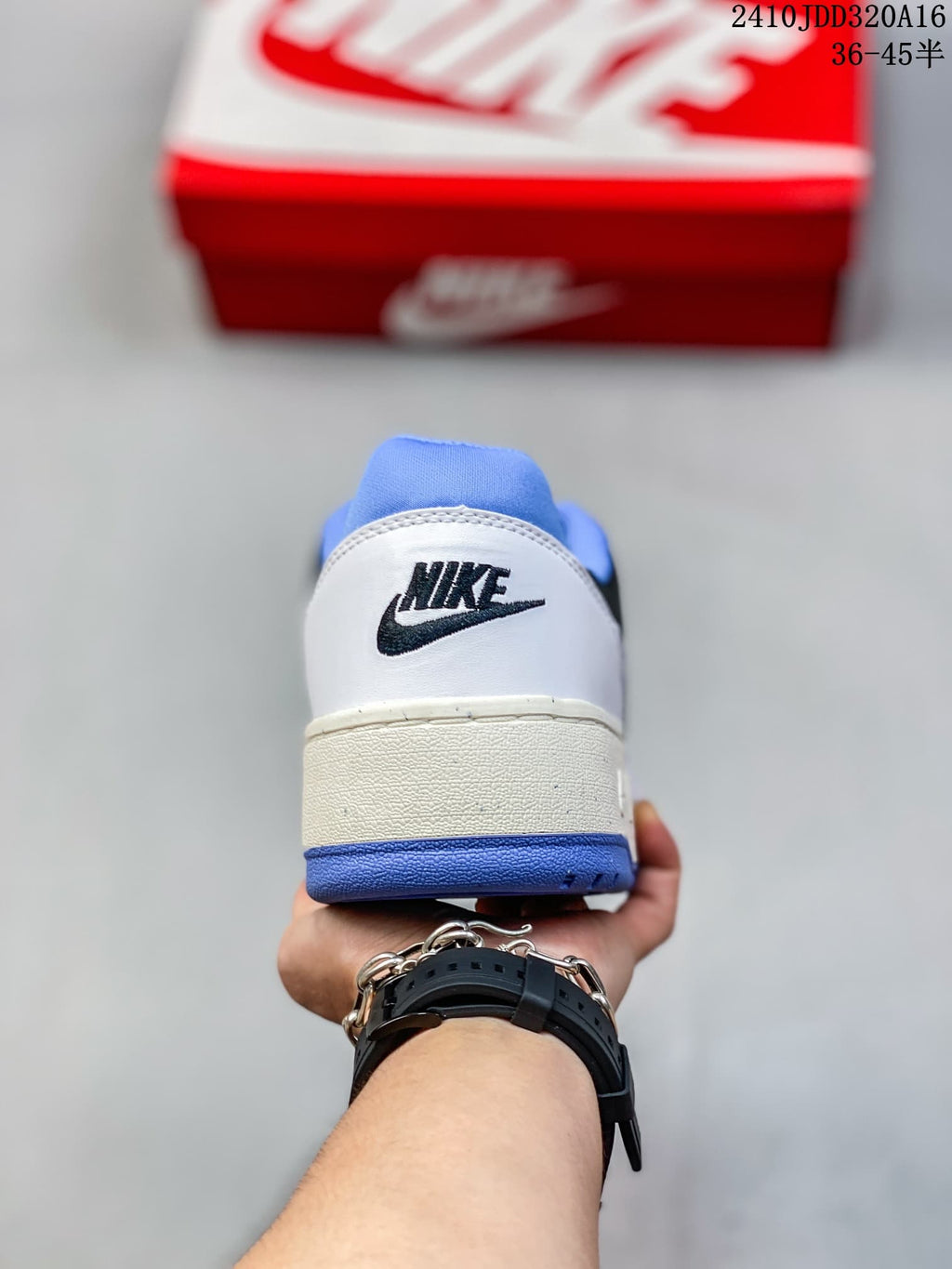 Heel view of a white Nike Full Force Low sneaker with a black logo and blue outsole.