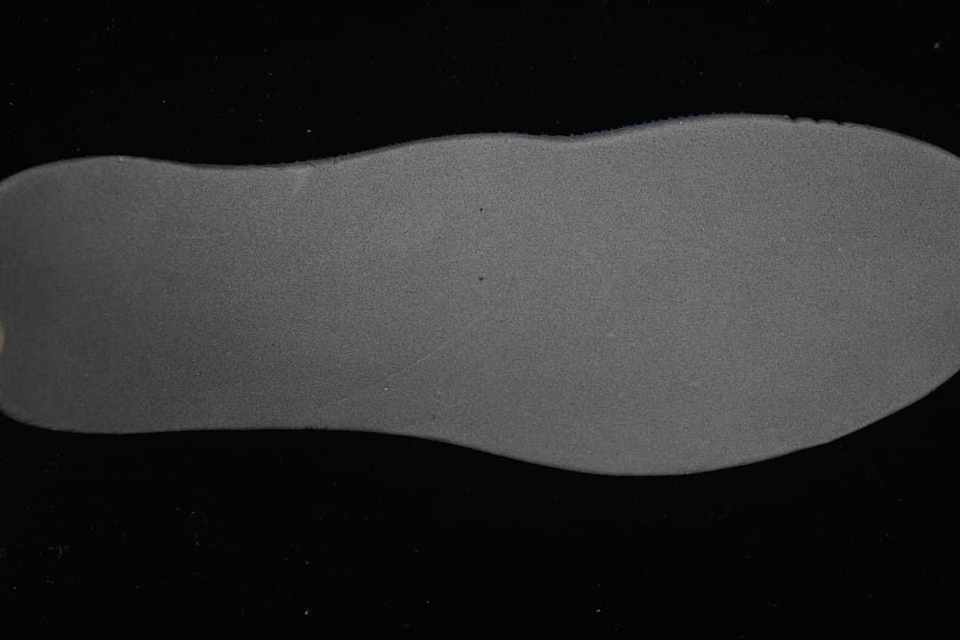 Gray shoe insole shown on a black background