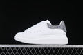 Side view of a white low-top sneaker with a silver-tone glitter heel panel.