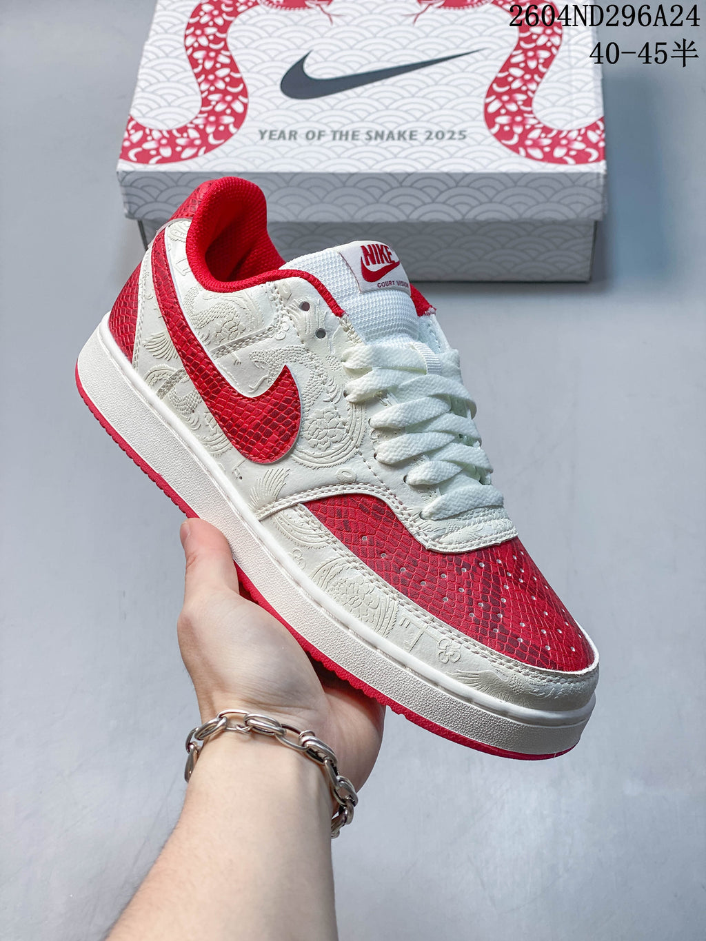 Angled close-up of the white and red Nike Court Vision sneaker with patterned panels