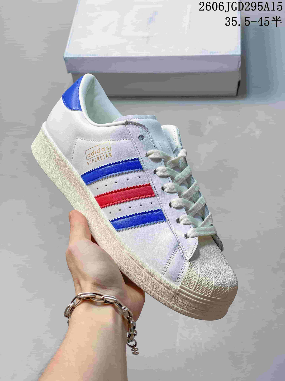 White sneaker with blue and red side stripes and a shell toe