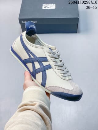 White Mexico 66 sneaker with blue side stripes and a dark navy outsole and heel accent.