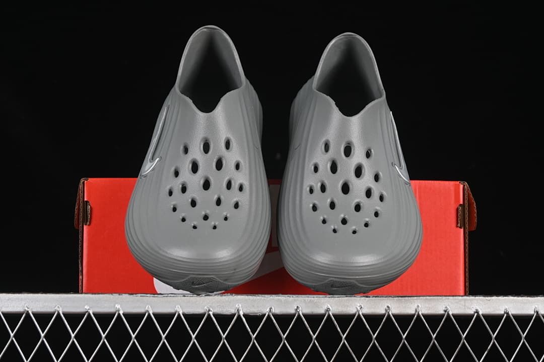 Front view of a pair of grey perforated clog sandals
