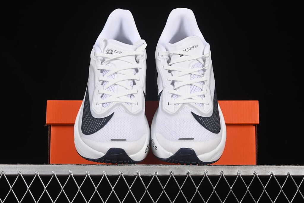 Front view of a pair of white running shoes displayed on an orange box.