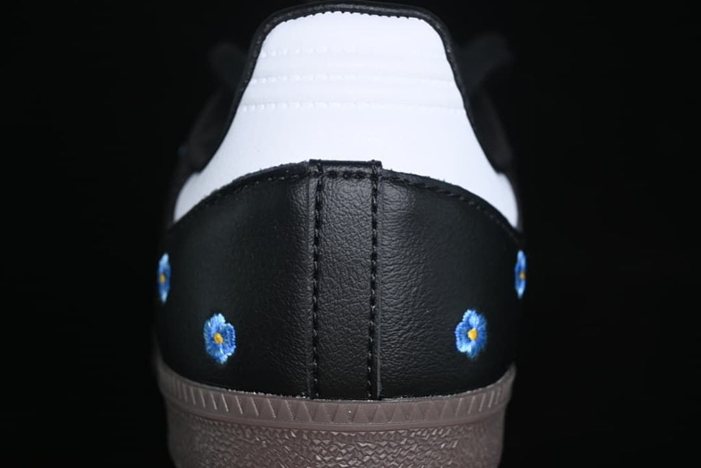 Rear close-up showing white heel panels and blue floral embroidery