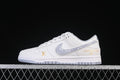 Side view of a white low-top sneaker with a gray patterned Swoosh and gold-tone branding