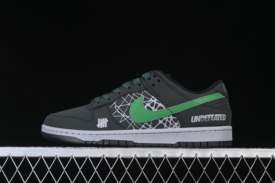 Side view of black low-top sneakers with green Swoosh and patterned side panels