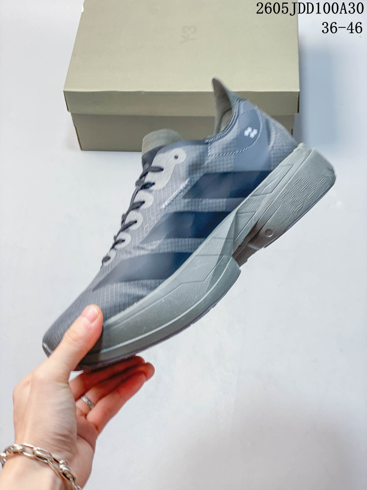 Side profile showing the gray upper, silver-tone stripes, and matching sole.