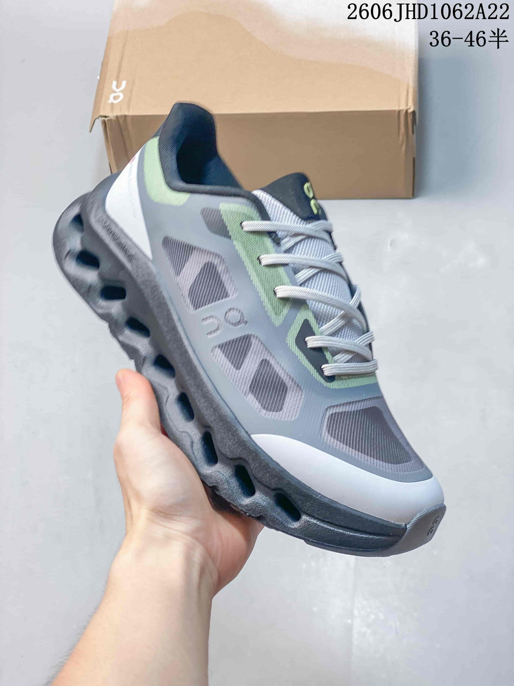 Angled view of a gray and lime On Cloudtilt Remix sneaker with its sculpted sole visible.