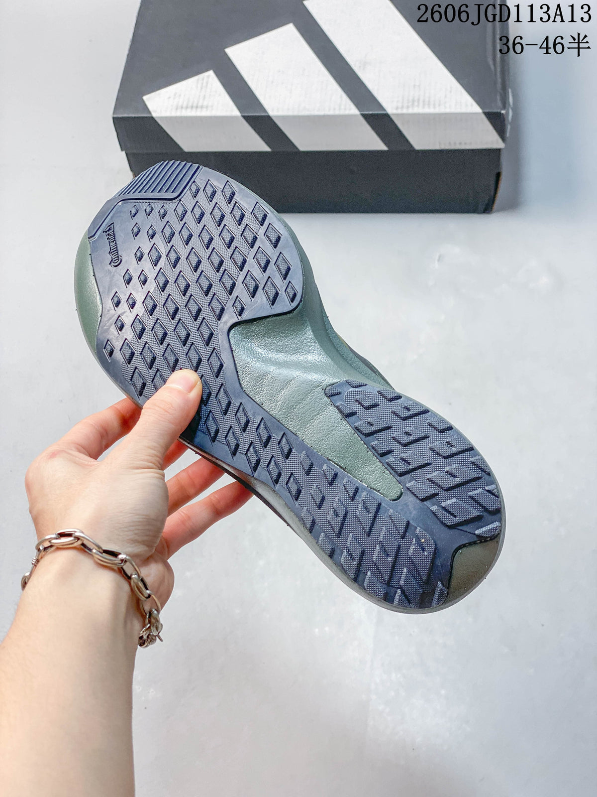 Close-up of the patterned outsole on an olive running shoe
