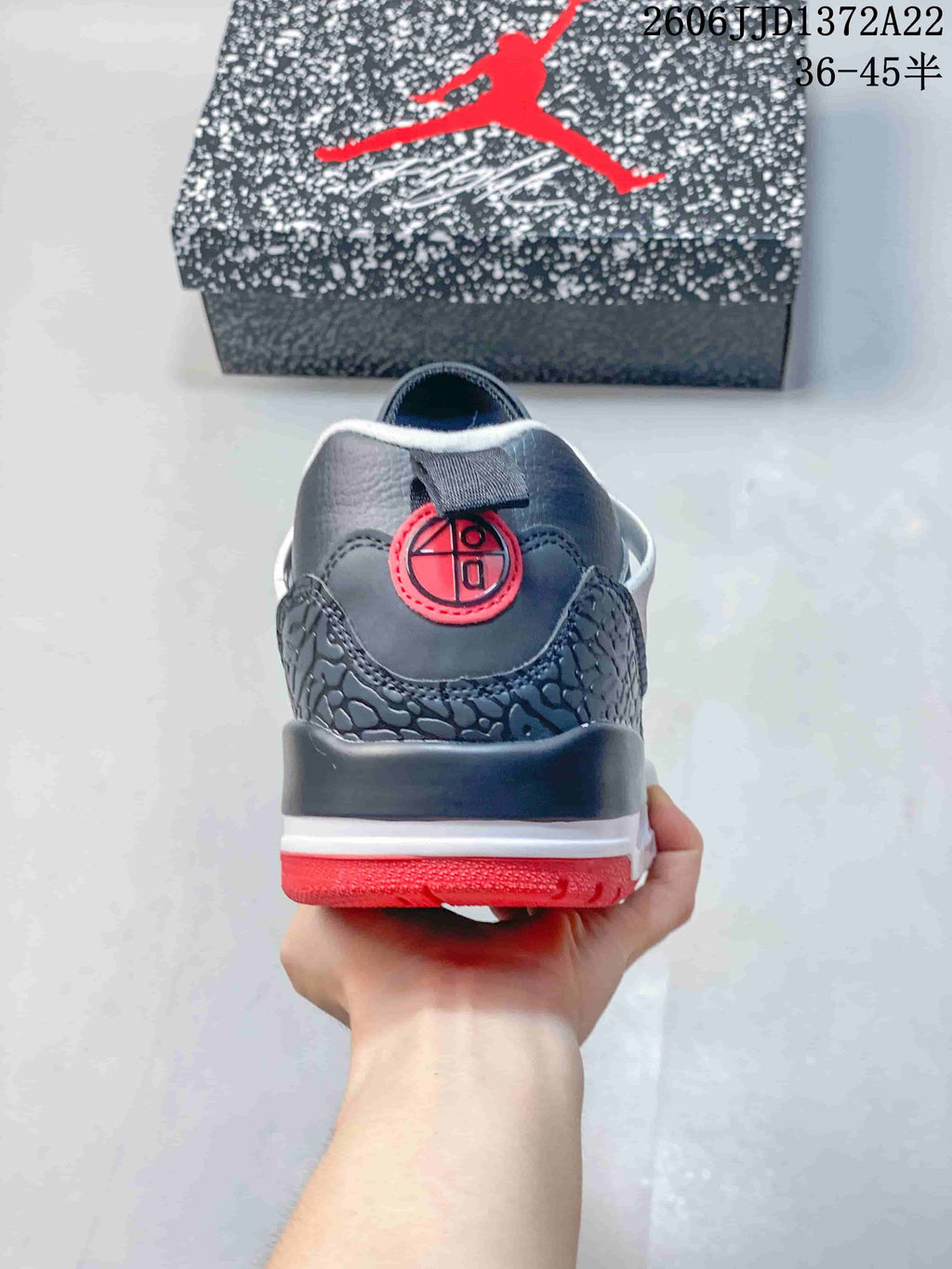 Rear view of a charcoal Jordan Spizike Low sneaker with a red heel detail