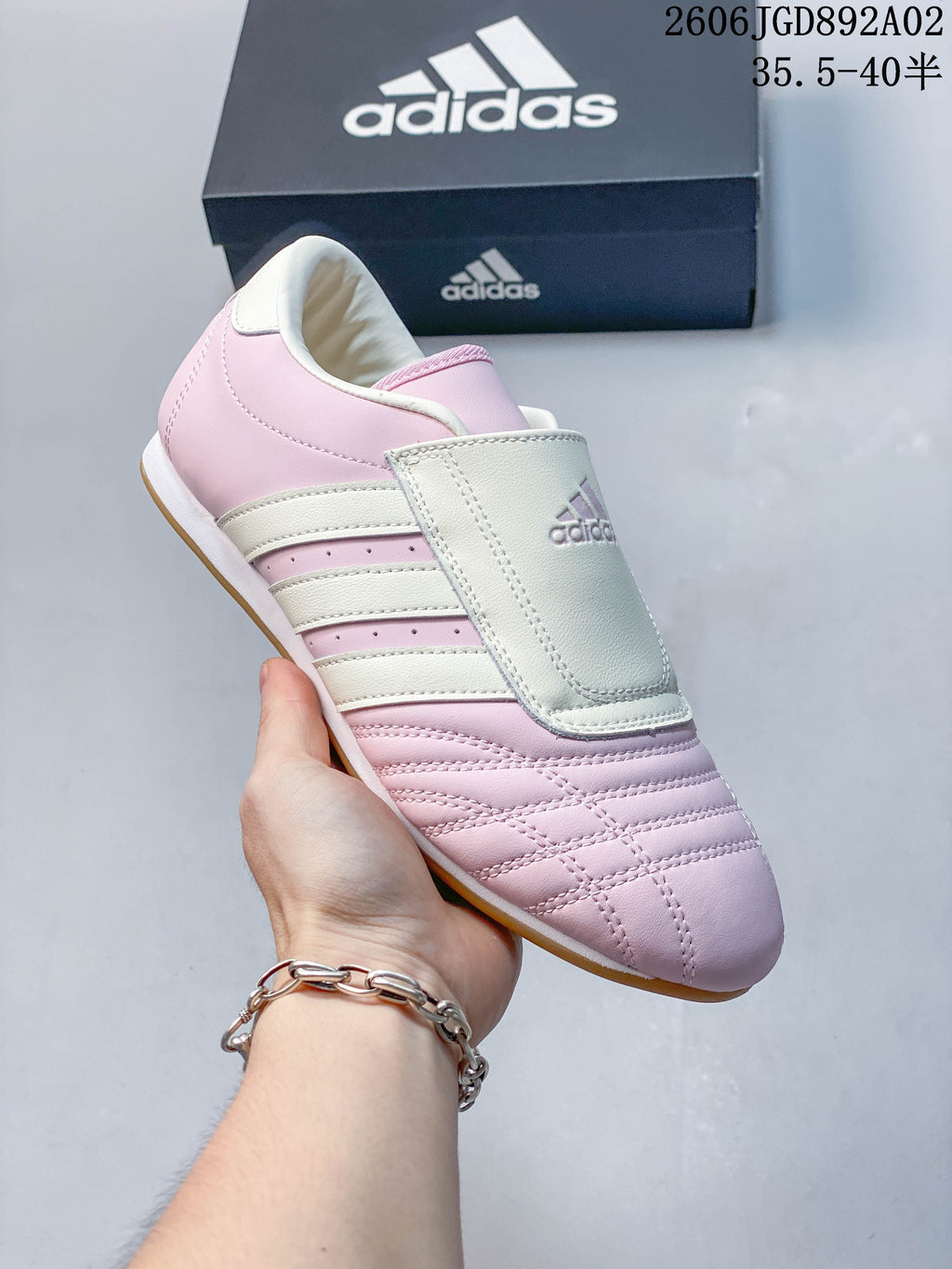Angled view of a pink and off-white Adidas Taekwondo shoe