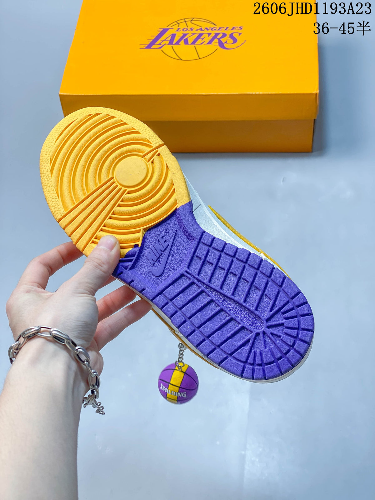 Gold and purple color-blocked outsole with a basketball-shaped charm and Lakers-branded shoe box