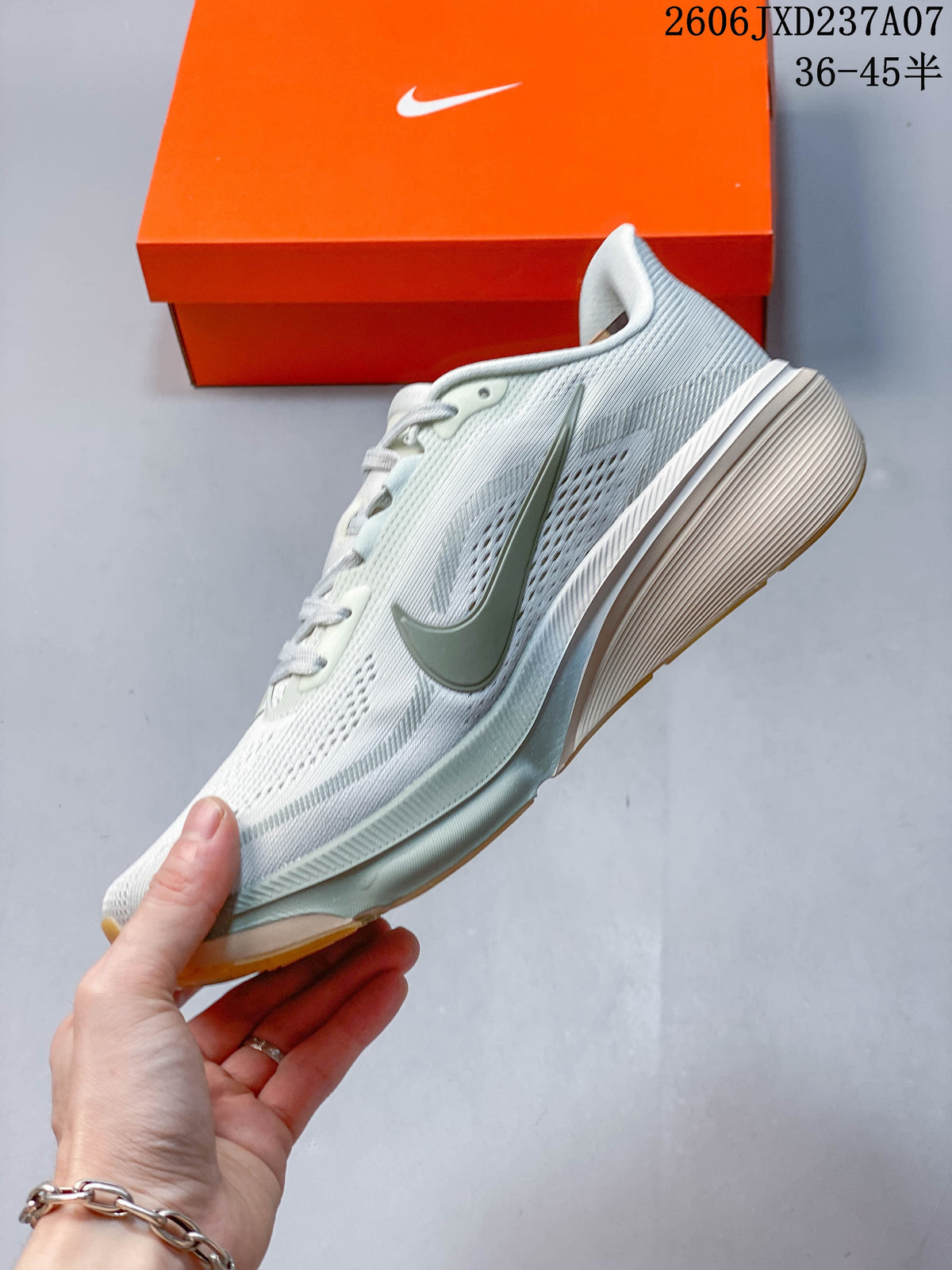 Side view of a light-colored Nike Pegasus 42 running shoe with muted green swoosh and midsole details.