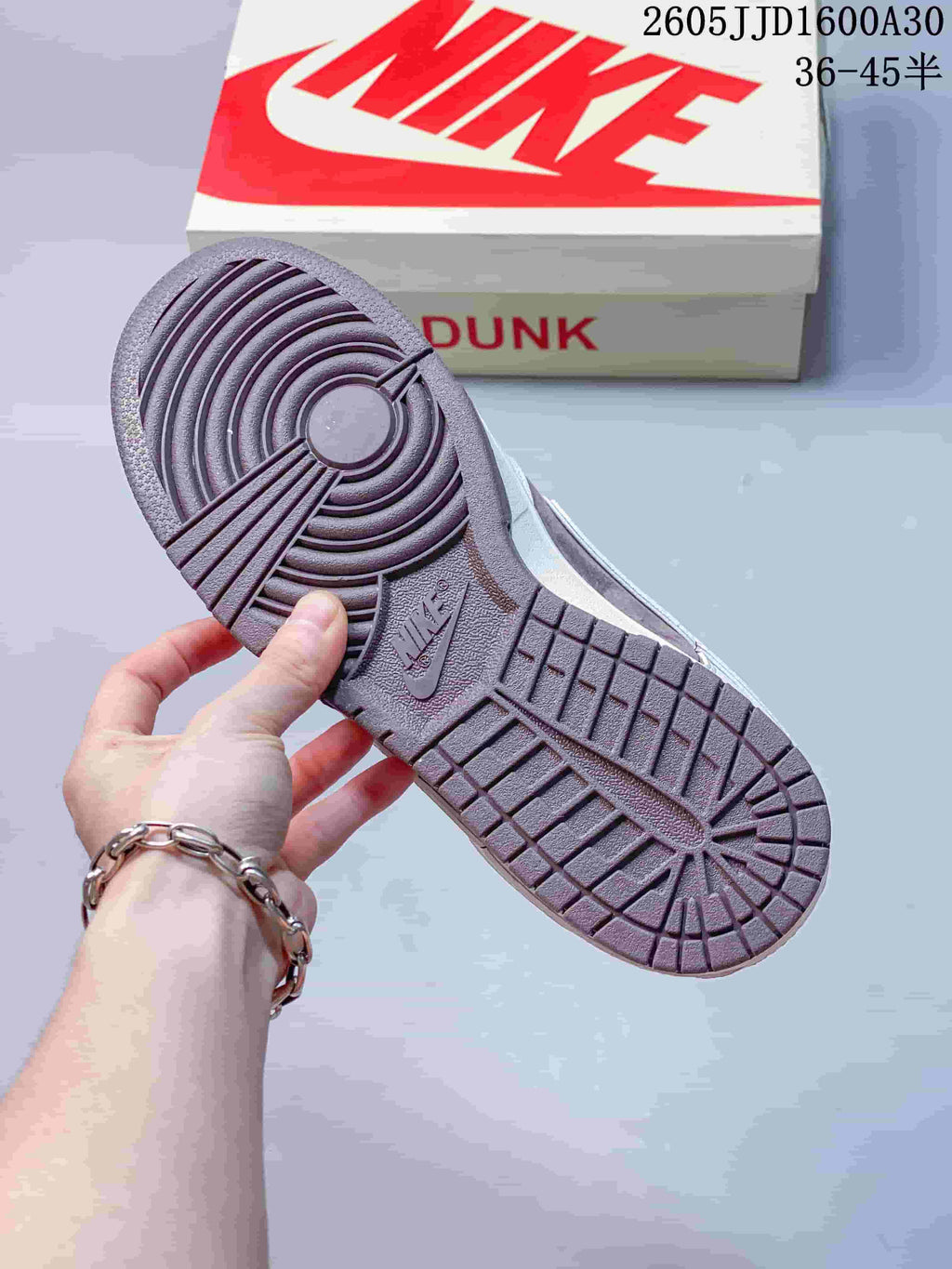 Close-up of mauve-brown rubber outsole tread and Dunk shoebox