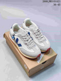 Pair of white and light gray Veja sneakers with blue side logos, shown on a shoe box