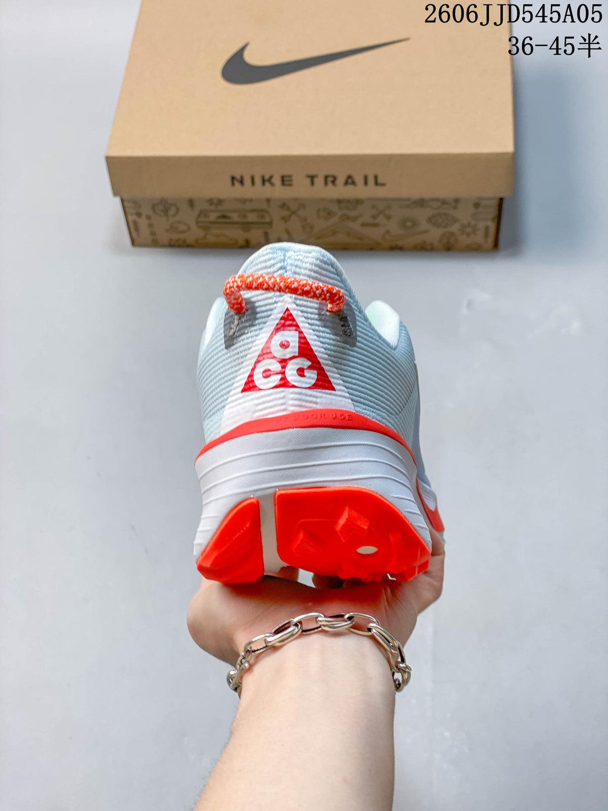Rear view of the shoe showing its heel loop and bright red-orange heel details.