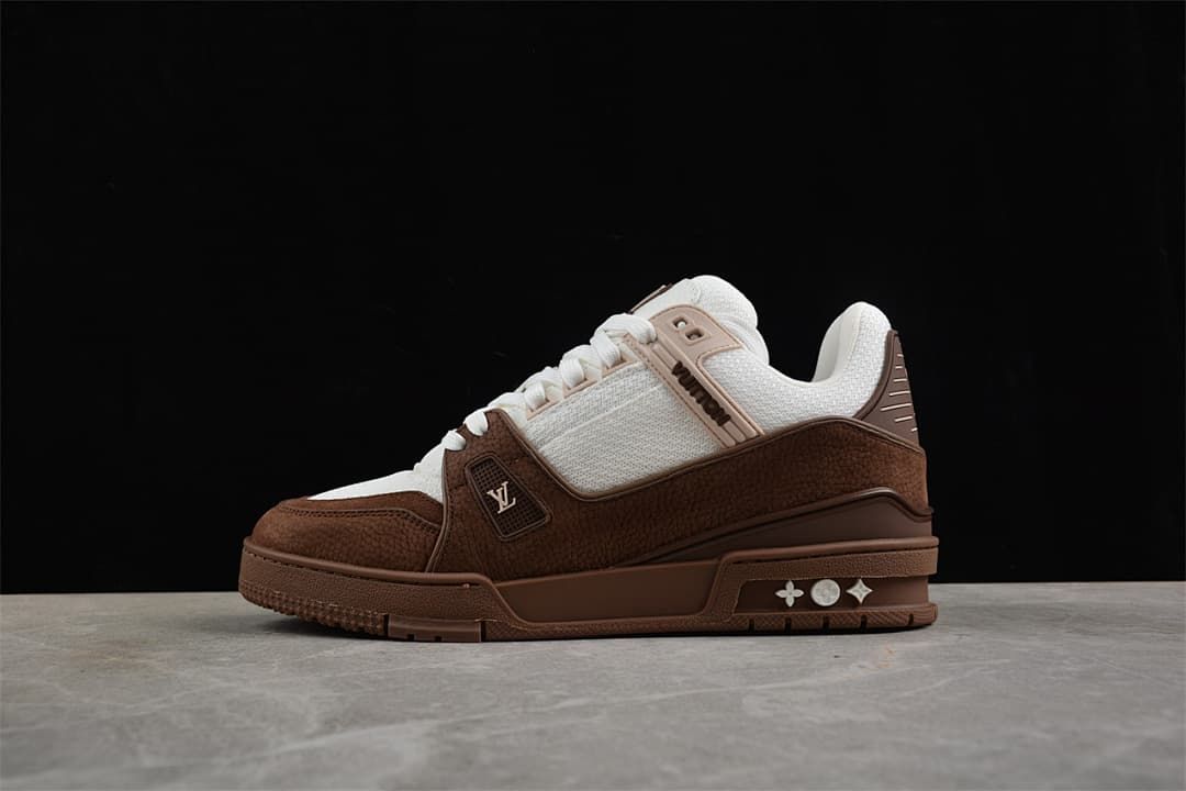 Side view of a brown and white sneaker against a dark background.