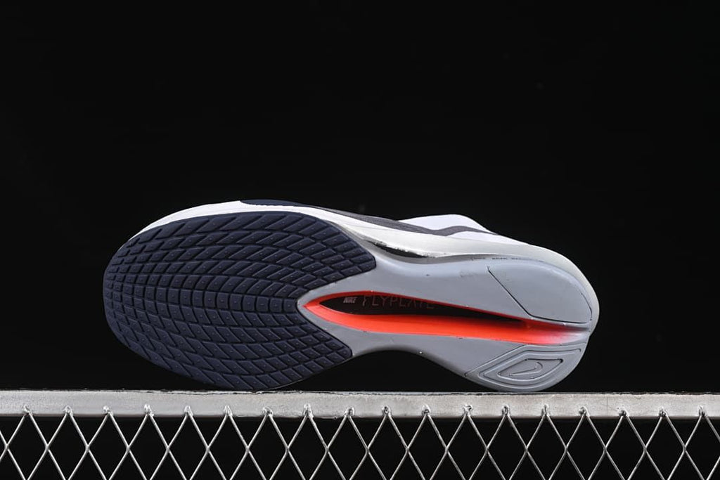Outsole view showing segmented dark and gray tread with a bright accent in the center.