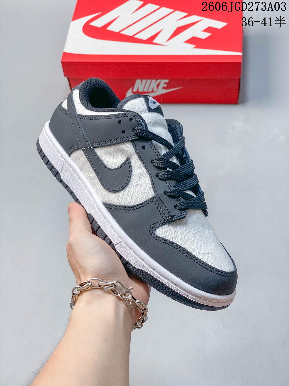 Side view of a black-and-white low-top Nike Dunk sneaker with patterned panels