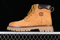 Side profile of a yellow-brown Timberland mid-top boot with laces and a chunky sole
