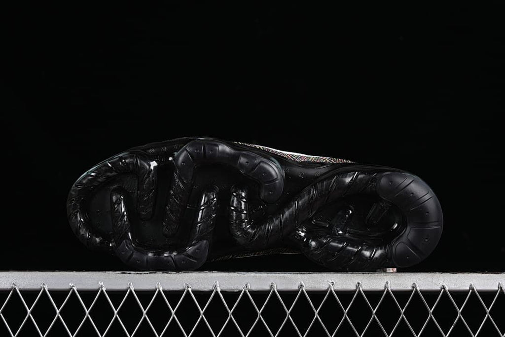 Underside of the black sneaker showing the outsole