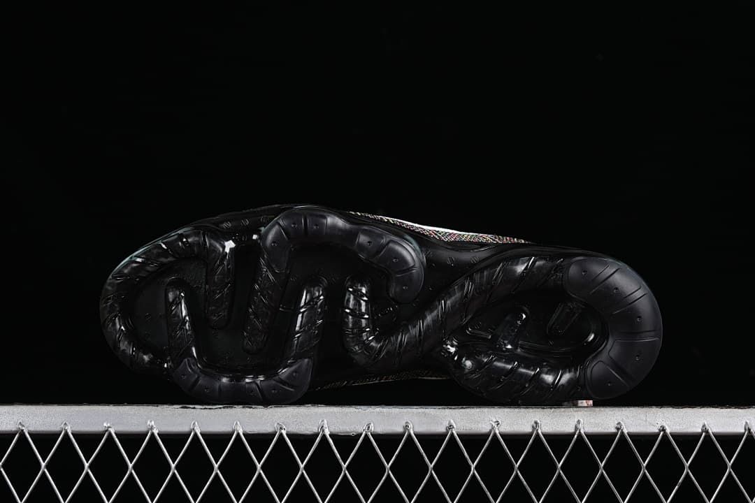 Underside of the black sneaker showing the outsole