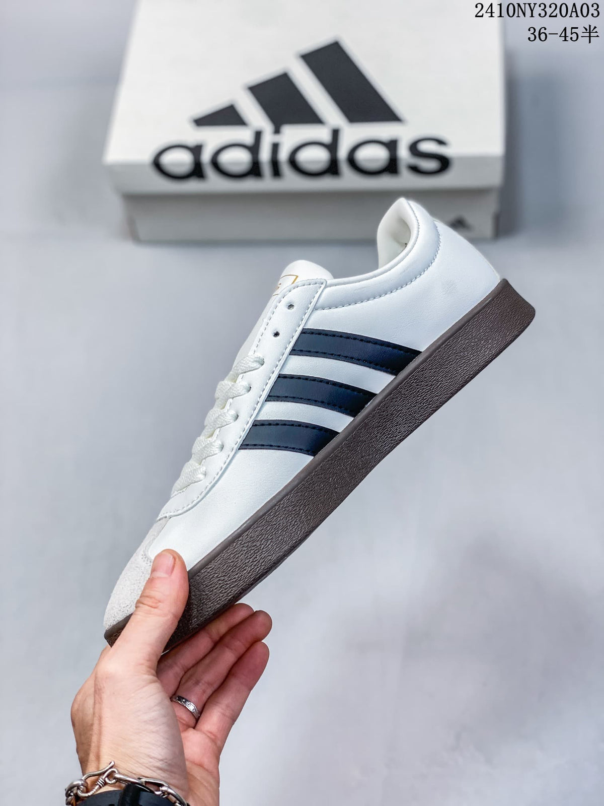Side view of the white low-top sneaker with navy stripes and a dark brown outsole