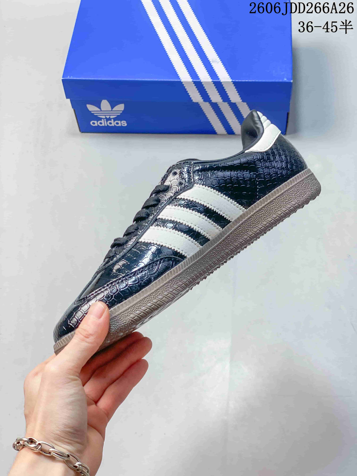 Side profile of a dark embossed-pattern Adidas Samba sneaker with white stripes and a gum-tone sole.