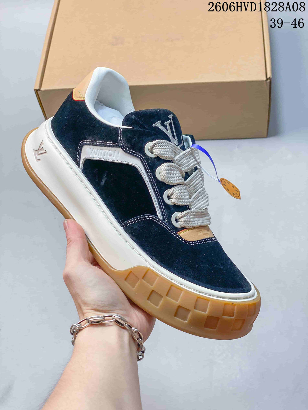 Angled side view showing navy upper, logo-decorated side panel, and gum-colored outsole