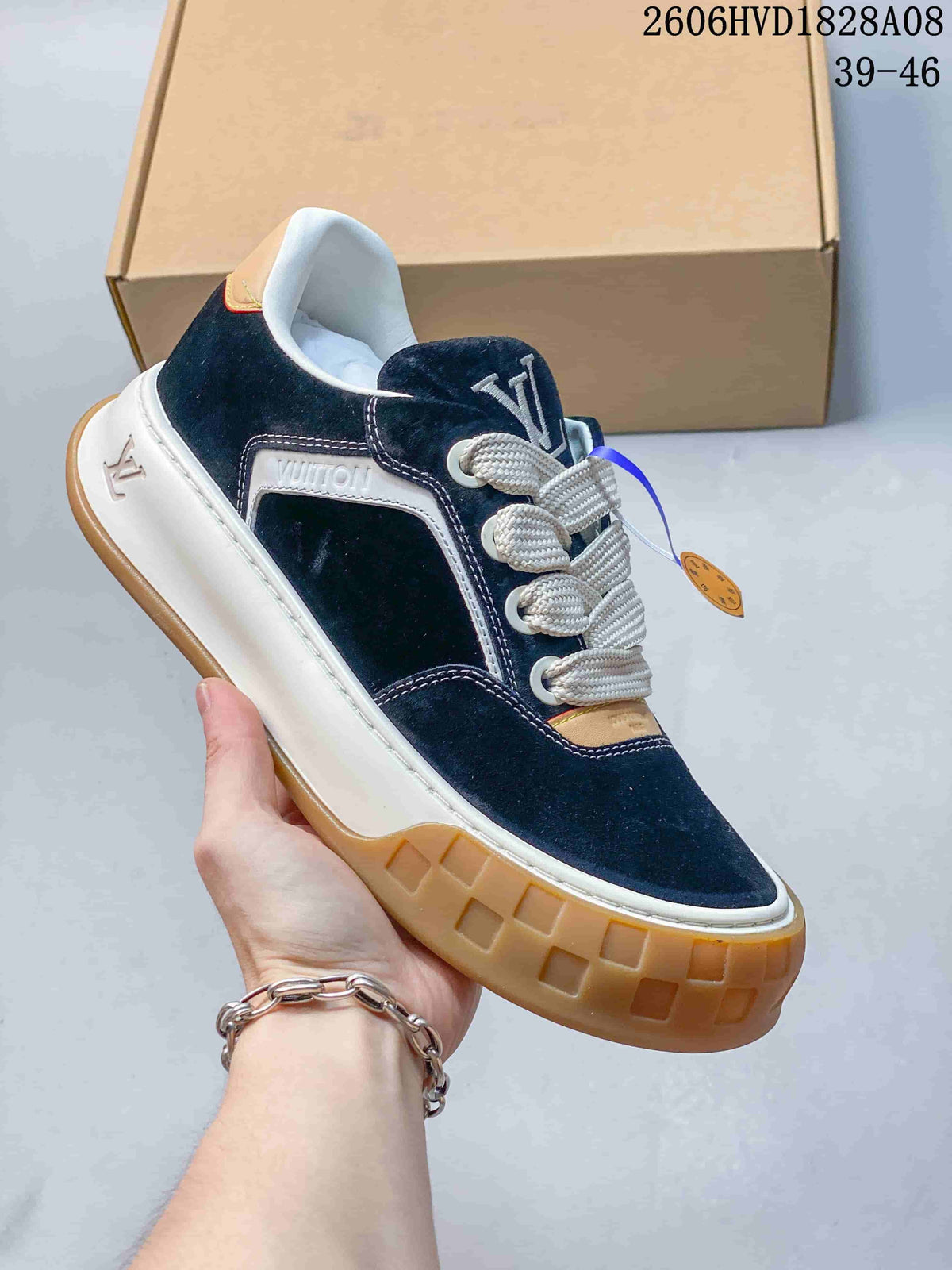 Angled side view showing navy upper, logo-decorated side panel, and gum-colored outsole