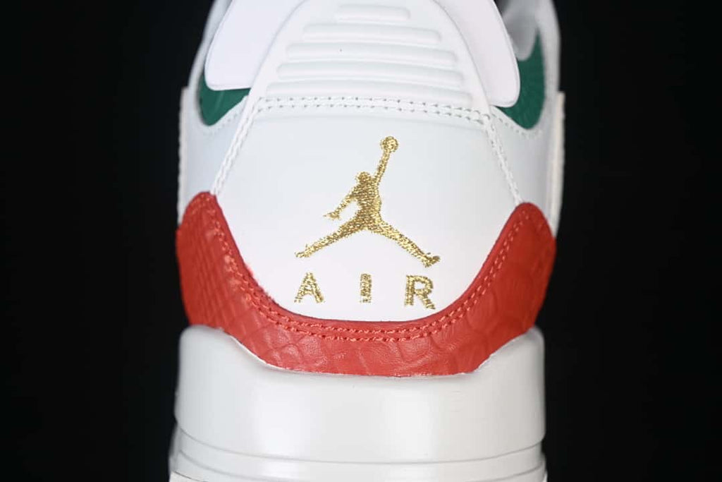 Rear view of the sneaker with a gold-tone heel emblem, red heel panel, and green collar accent