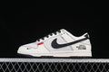 Side view of an off-white and black Nike SB Dunk Low with The North Face branding and a small red accent