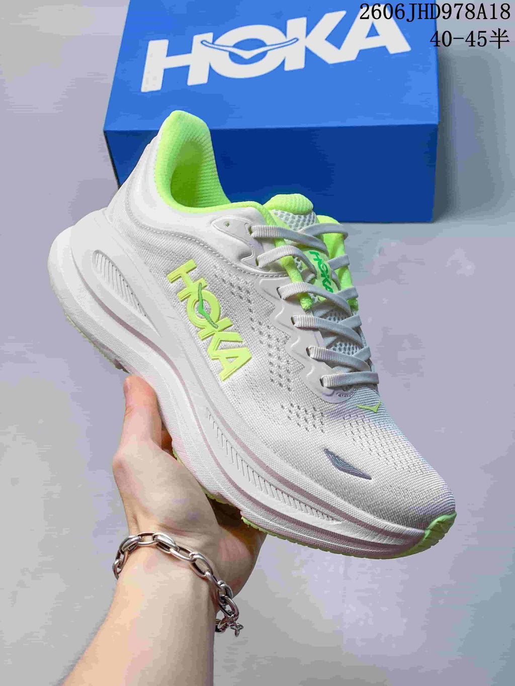 Angled side view of a white HOKA Bondi 9 shoe with neon-green accents