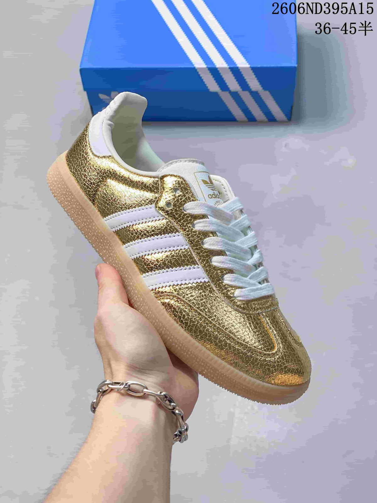 Side view of a gold-tone metallic low-top sneaker with white stripes