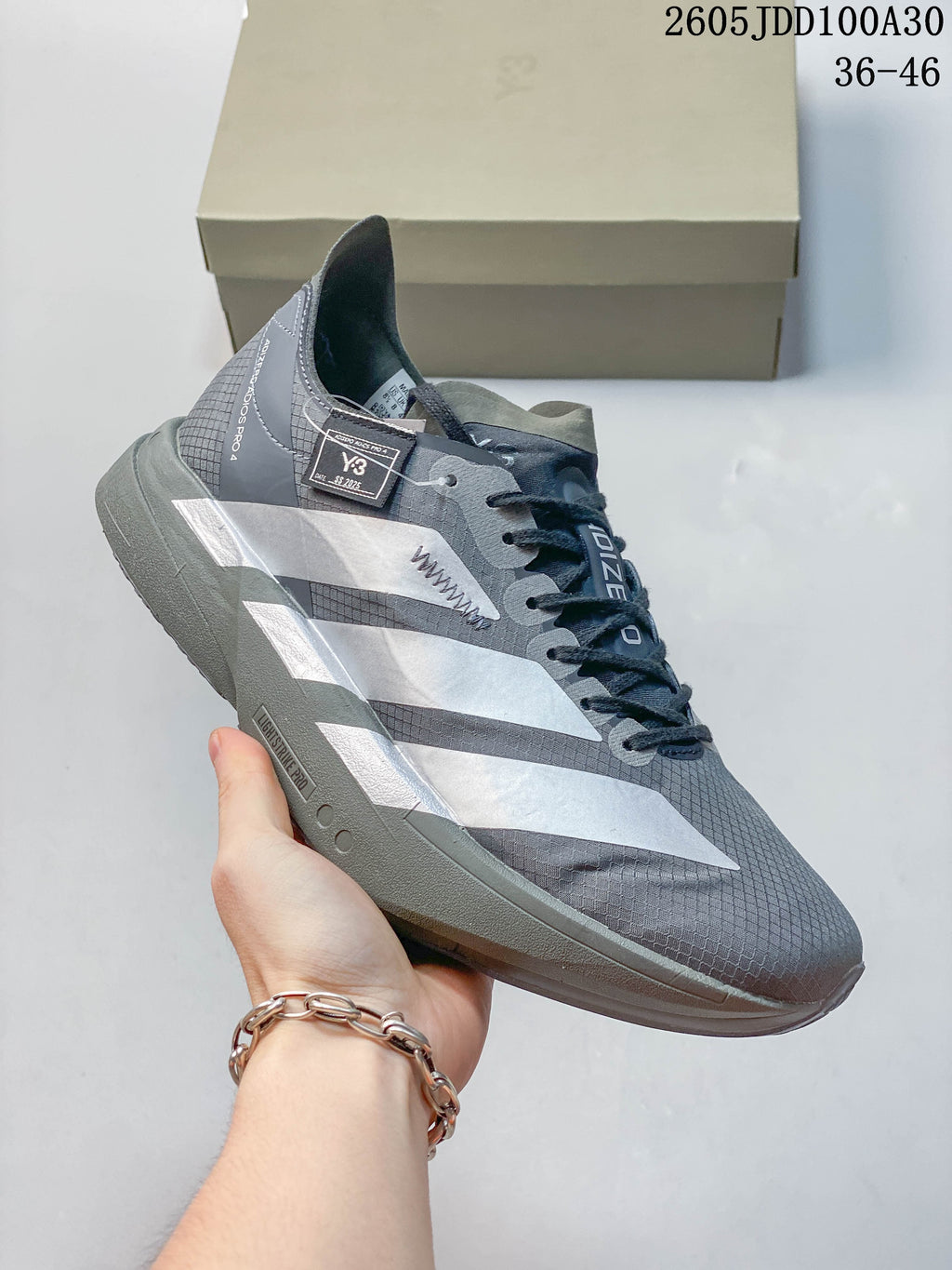 Side view of the gray Adidas Adizero Adios Pro 4 shoe with silver-tone stripes.