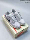 Pair of light grey and navy Nike SB Dunk Low style sneakers displayed on a branded box