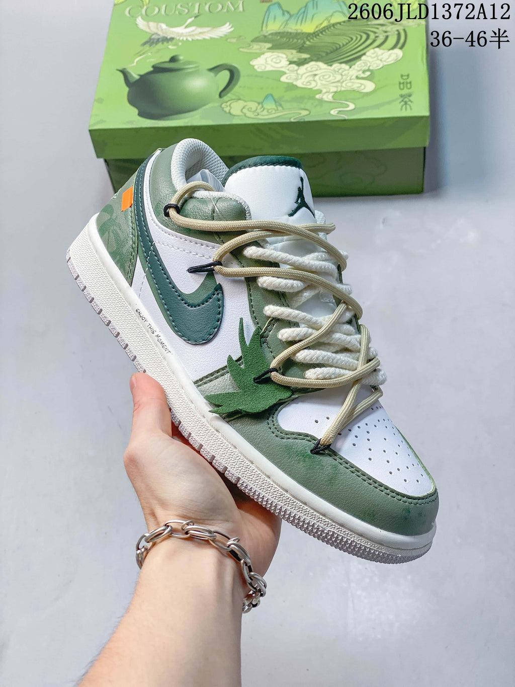 Angled side view of a white and green low-top sneaker with a teal Swoosh