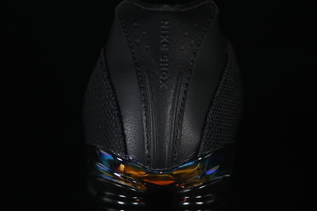 Rear close-up showing Shox lettering and iridescent heel detail.