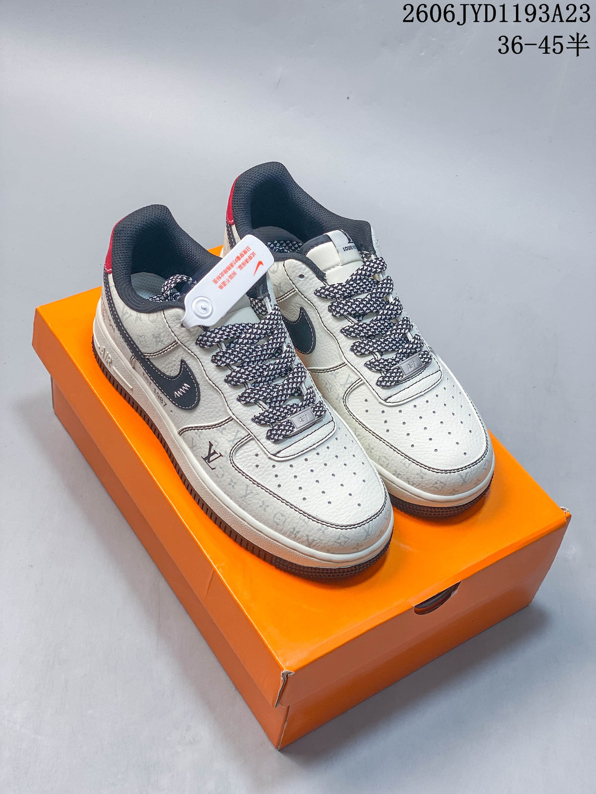 Cream low-top sneakers with dark swoosh-style overlays, patterned laces, and a patterned surface, displayed on an orange box.