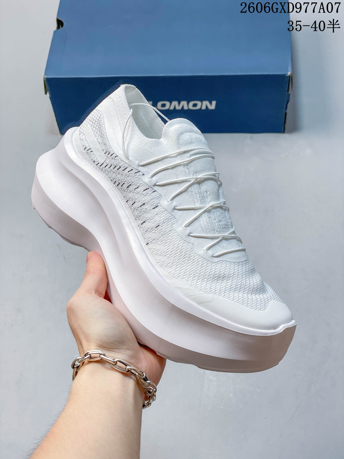 Angled side view of a white sneaker with a textured upper and thick platform sole.