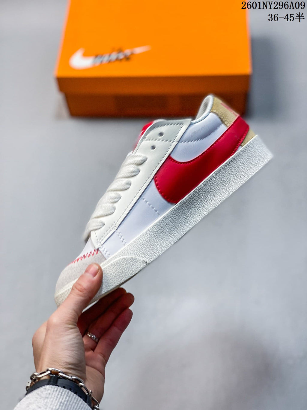 Side view of the low-top sneaker with a large red Swoosh and cream-colored sole.