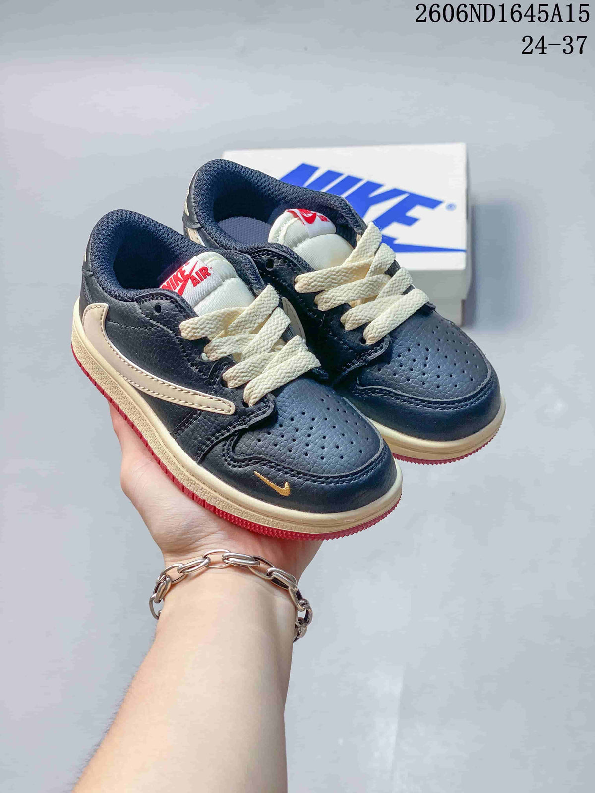 Pair of navy kids’ low-top sneakers with cream laces, cream side details, and red outsoles.