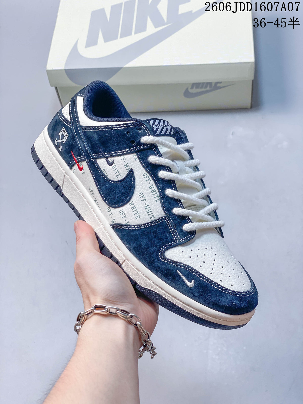 Close-up of a navy and white low-top sneaker with text-print panels and contrasting accents.