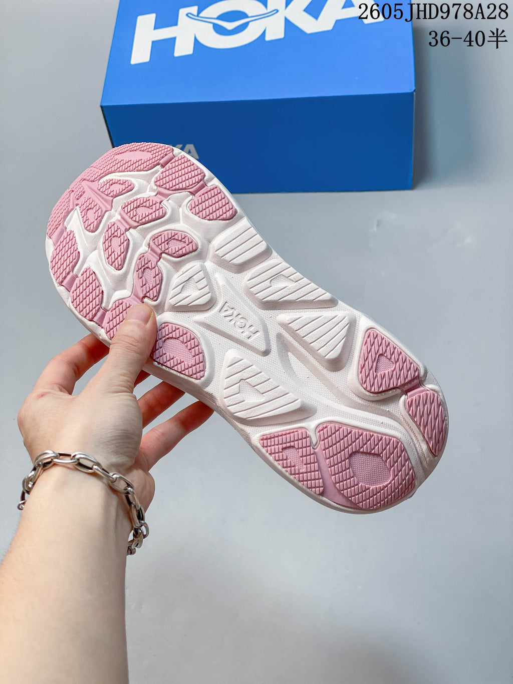 Underside of a HOKA Clifton 10 shoe showing a white and pink patterned outsole