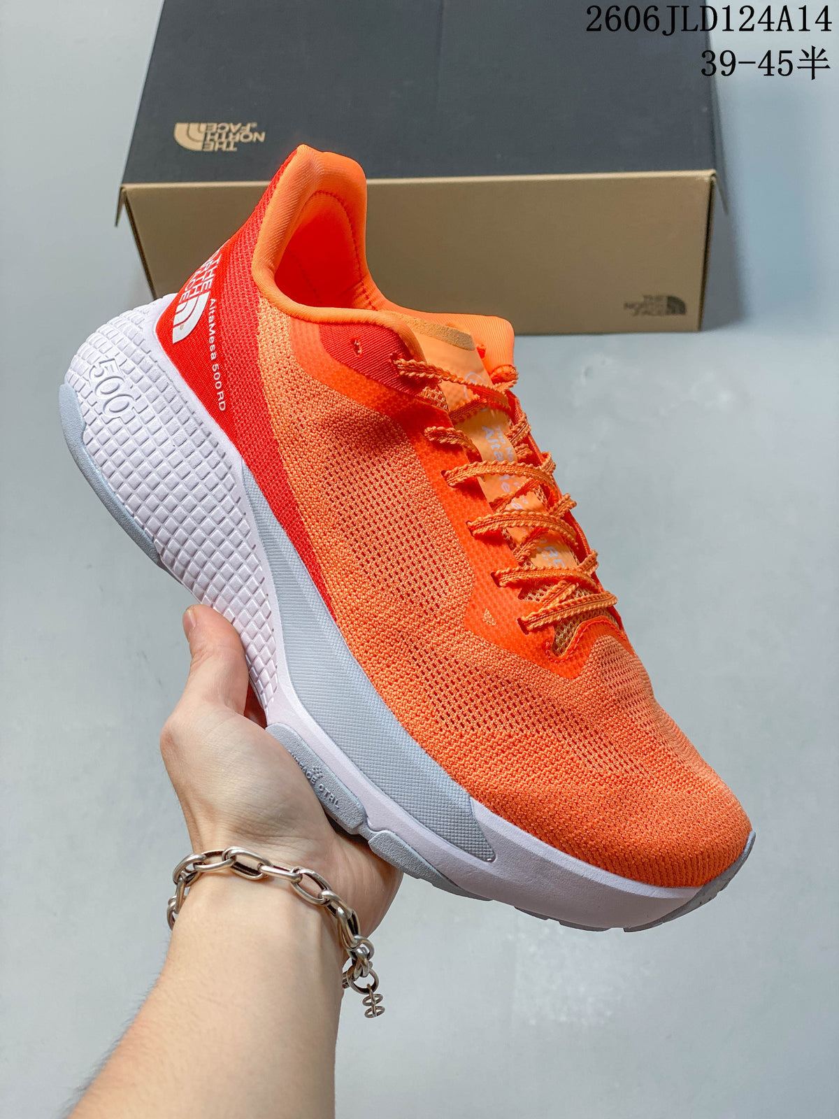Side view of an orange trail-running shoe showing its textured outsole