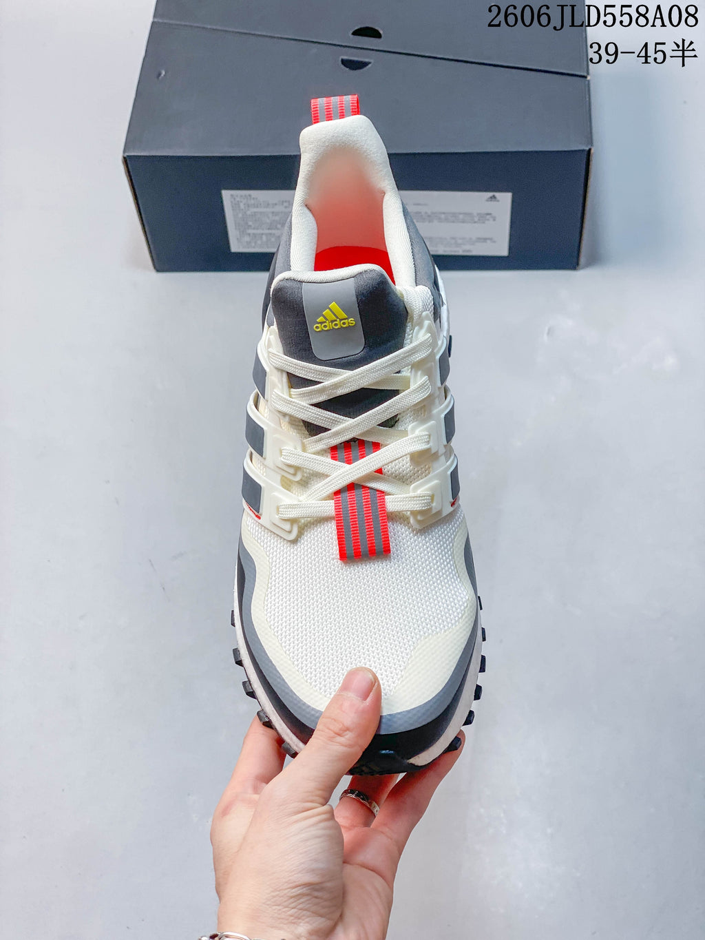 Front view highlighting the white upper, lace-up closure and red lace detail.