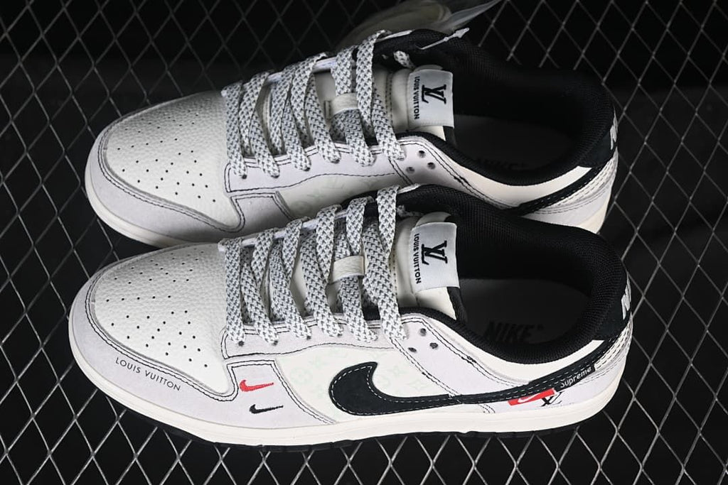 Top view of a pair of white and black low-top sneakers showing perforated toes and patterned laces
