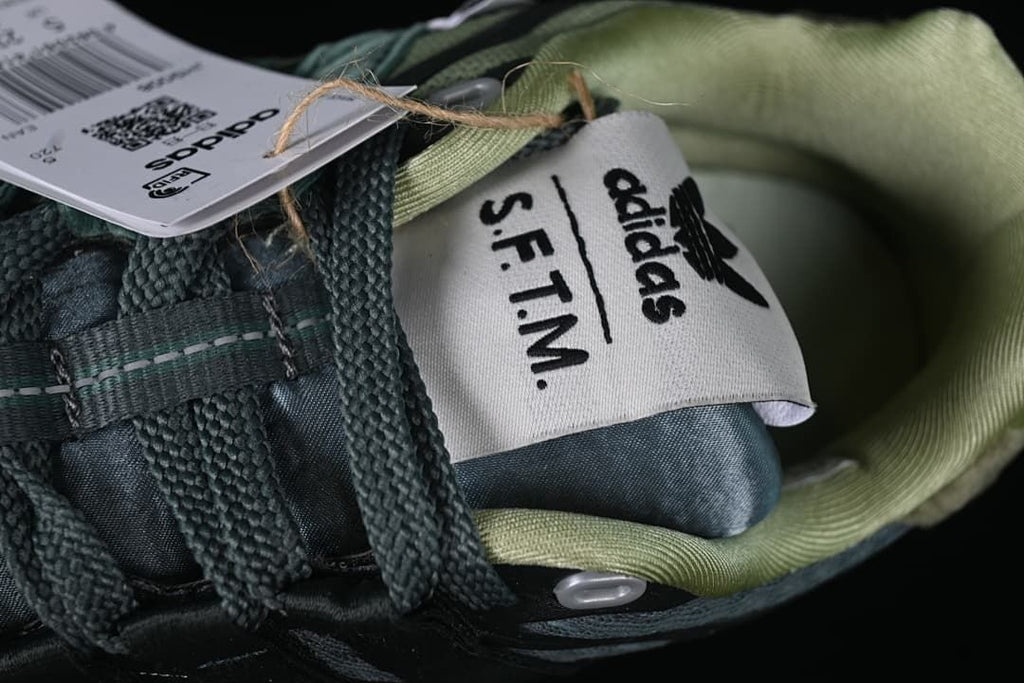 Close-up of the tongue label with adidas and S.F.T.M. branding.