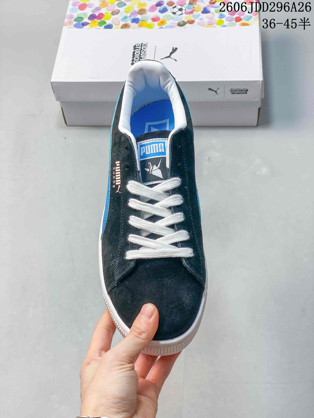 Top view of a dark lace-up sneaker with white laces and blue insole details.